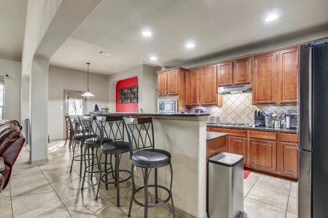 a kitchen with stainless steel appliances granite countertop a refrigerator and microwave