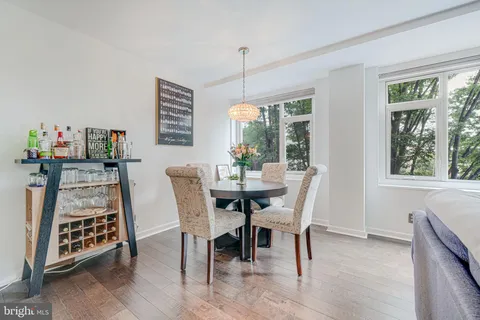 a dining room with furniture a chandelier and wooden floor