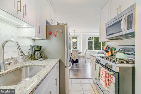 a kitchen with stainless steel appliances granite countertop a sink stove and cabinets