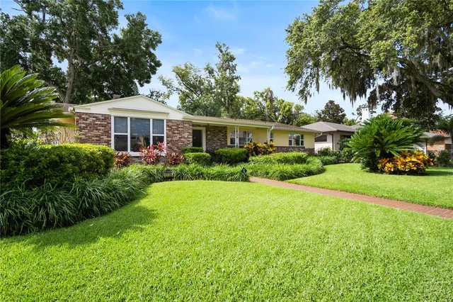 a front view of a house with a yard and potted plants