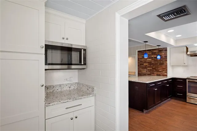 a kitchen with stainless steel appliances granite countertop a stove and a microwave