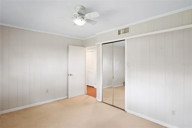 an empty room with a ceiling fan and a window