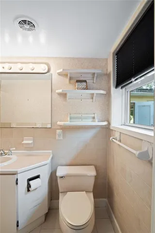 a bathroom with a toilet a sink and a large mirror