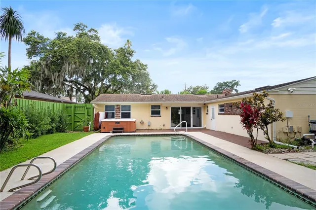 a view of a house with swimming pool and a yard