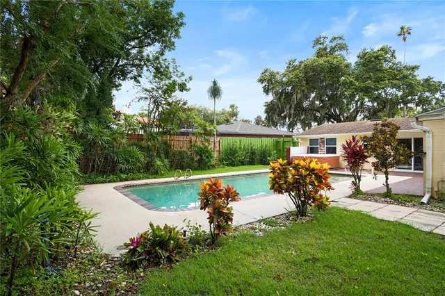 a view of a swimming pool with lawn chairs and a fire pit