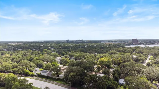 an aerial view of a city with lots of residential buildings ocean and mountain view in back