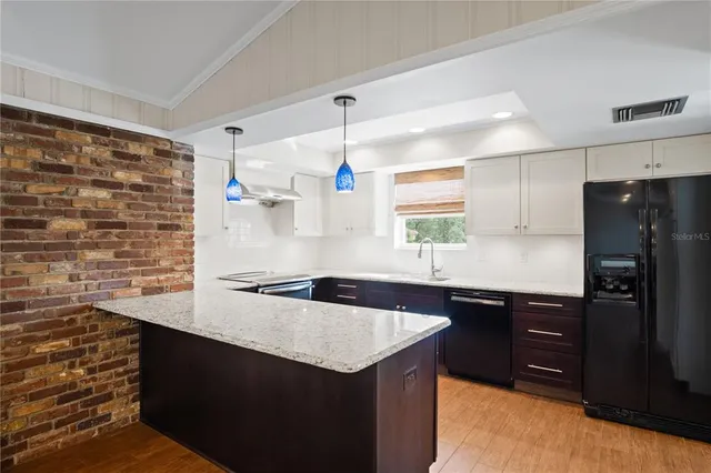 a kitchen with granite countertop a sink and a refrigerator