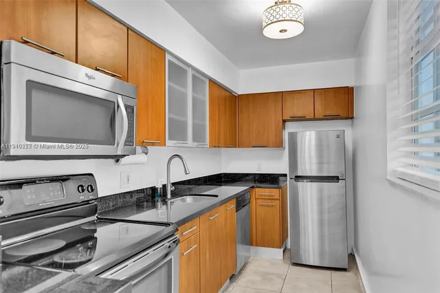 a kitchen with a sink a refrigerator and a microwave