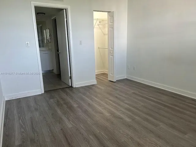an empty room with wooden floor and closet