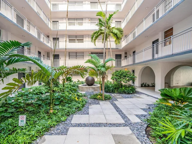 a view of a multi story building with a yard