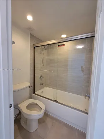 a bathroom with a shower a bathtub and a toilet