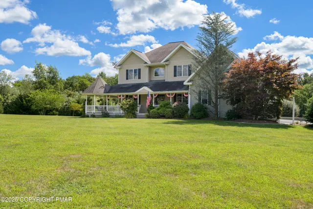 a front view of a house with a yard outdoor seating and garage