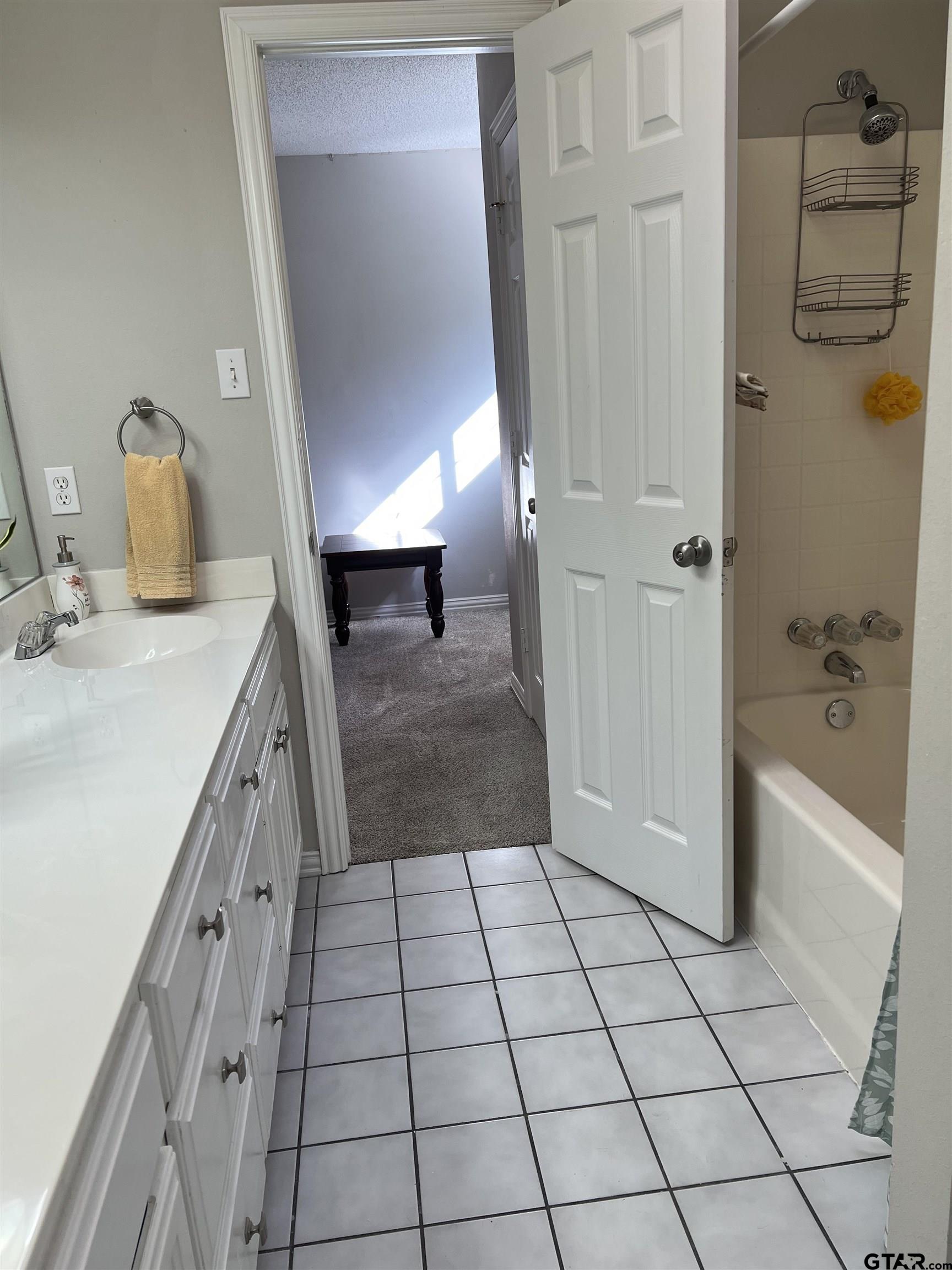2007 Villa Drive Tyler, TX 75703 - Photo 18 of 27 a bathroom with a granite countertop sink a mirror and shower