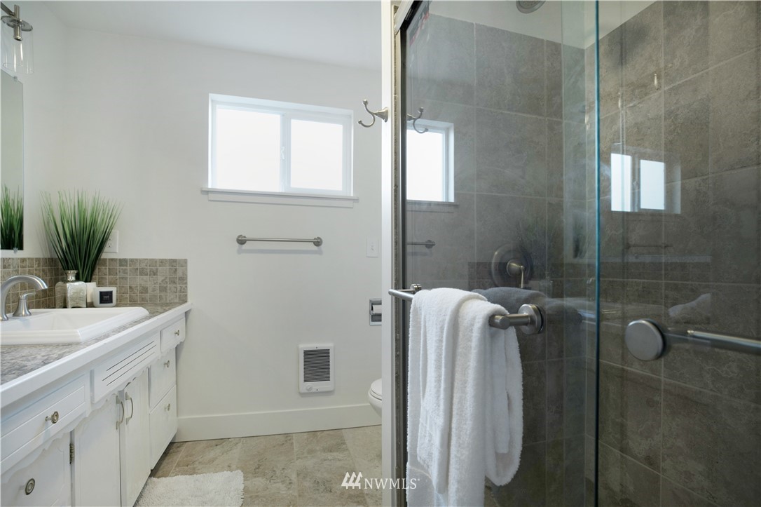 314 3rd Street Roy, WA 98580 - Photo 18 of 30 a bathroom with a sink a mirror and shower