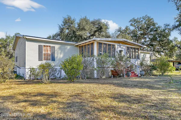a view of a house with a yard and furniture