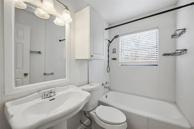 a bathroom with a toilet a sink a mirror and bathtub