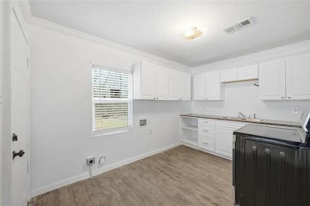 a kitchen with granite countertop white cabinets and white appliances