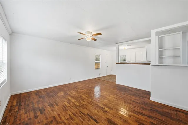 a view of a big room with wooden floor and a ceiling fan