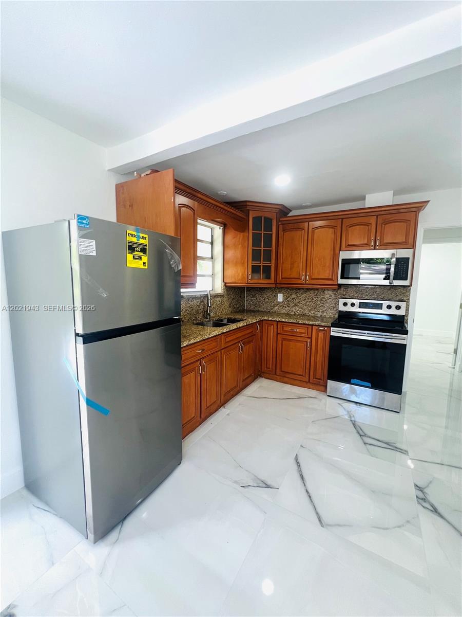 15530 Southwest 295th Terrace Homestead, FL 33033 - Photo 5 of 14 a kitchen with stainless steel appliances granite countertop a refrigerator a sink a stove a microwave and island