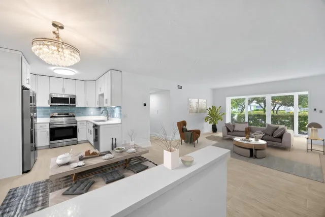 a living room with furniture kitchen and a large window