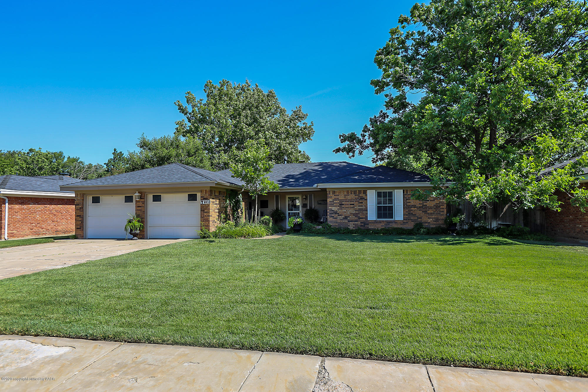 6012 Gainsborough Road Amarillo, TX 79106 - Photo 1 of 15 a front view of a house with a garden and trees
