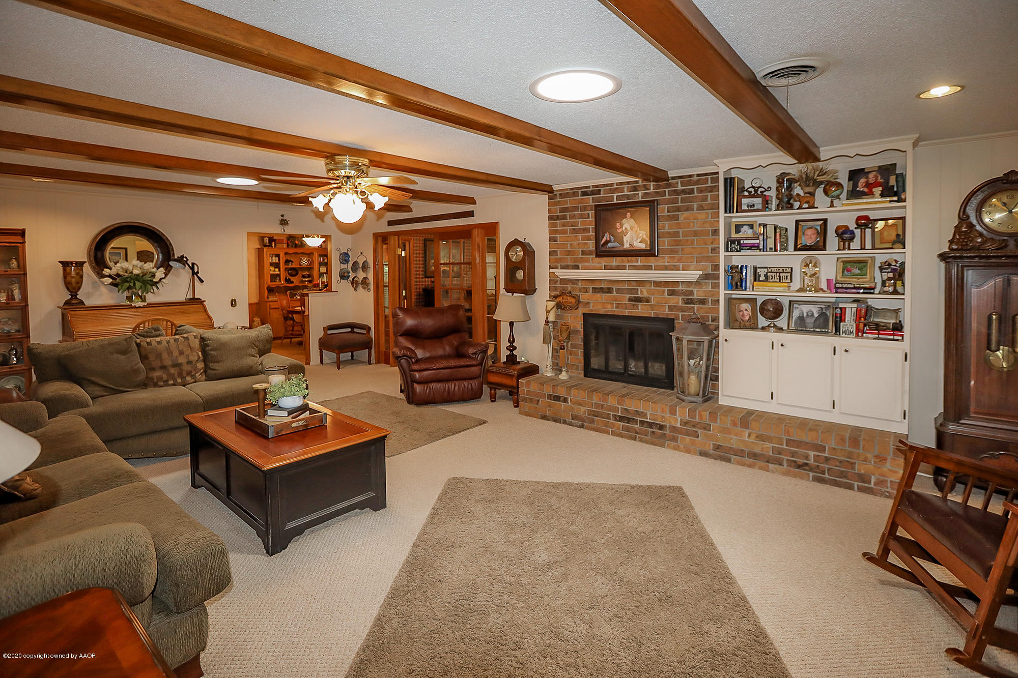 6012 Gainsborough Road Amarillo, TX 79106 - Photo 5 of 15 a living room with furniture a flat screen tv and a fireplace