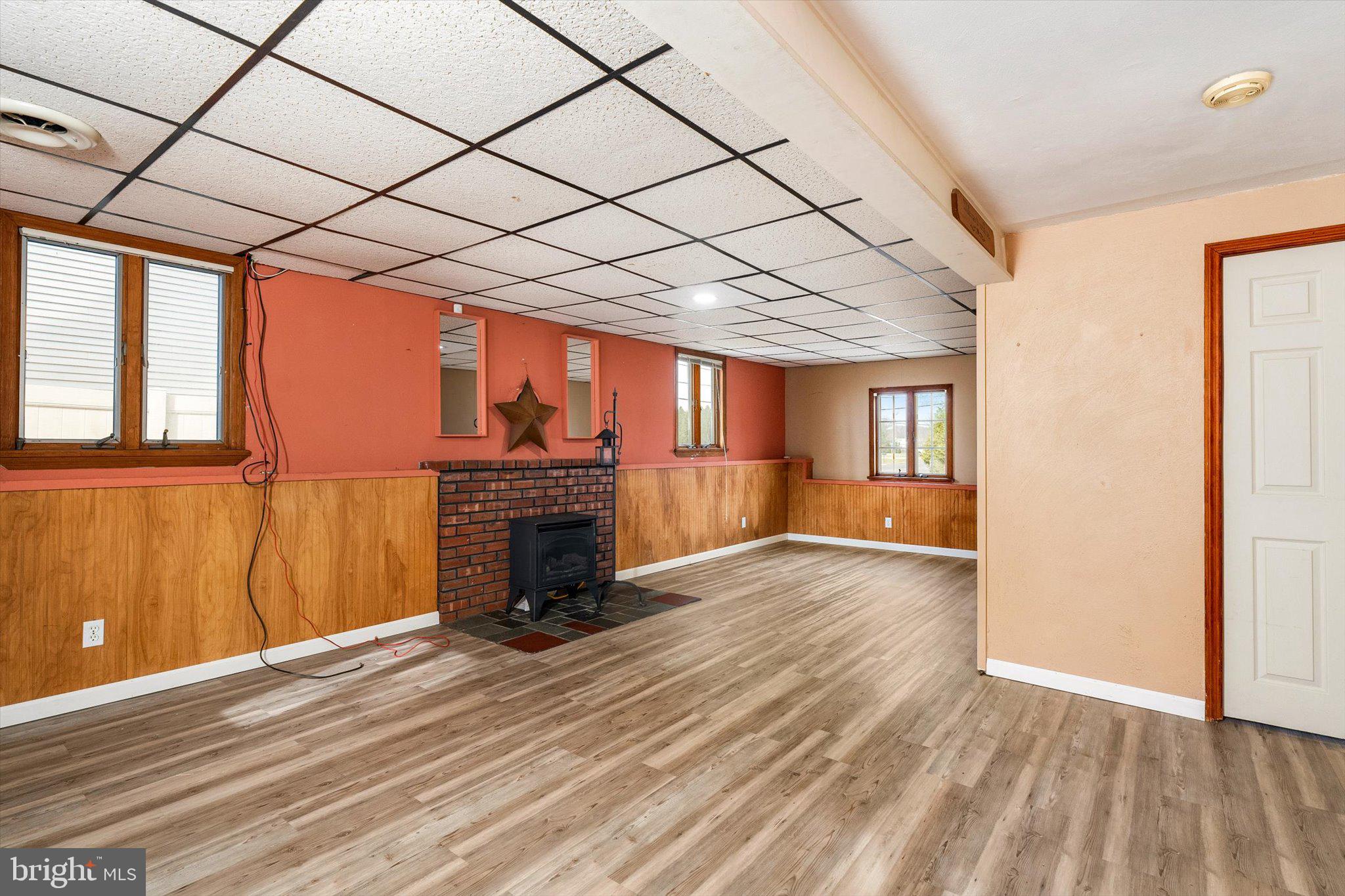 77 Gary Drive Hamilton, NJ 08690 - Photo 17 of 26 an empty room with wooden floor fireplace and windows