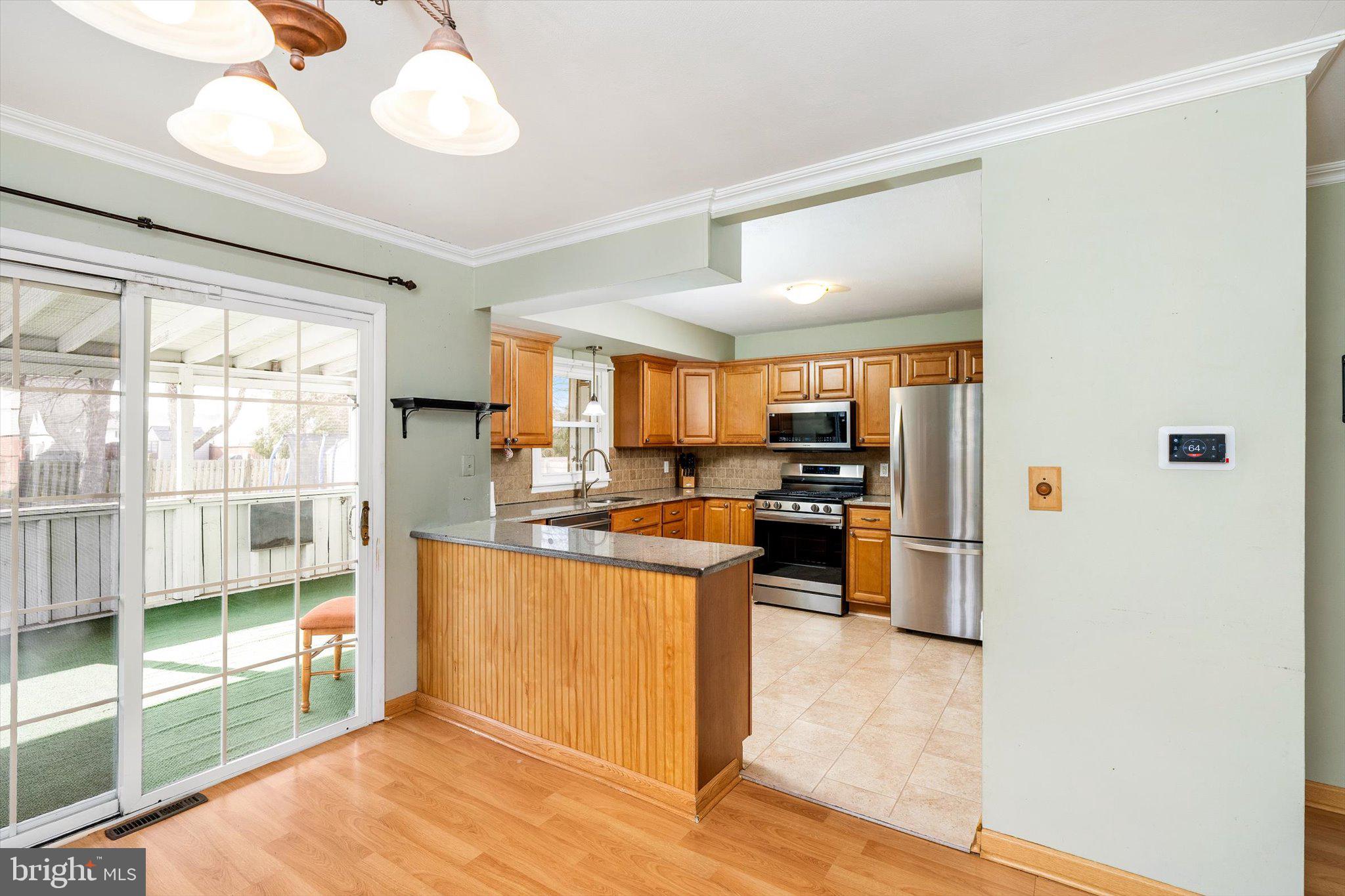 77 Gary Drive Hamilton, NJ 08690 - Photo 8 of 26 a kitchen with stainless steel appliances kitchen island granite countertop a stove and a view of living room