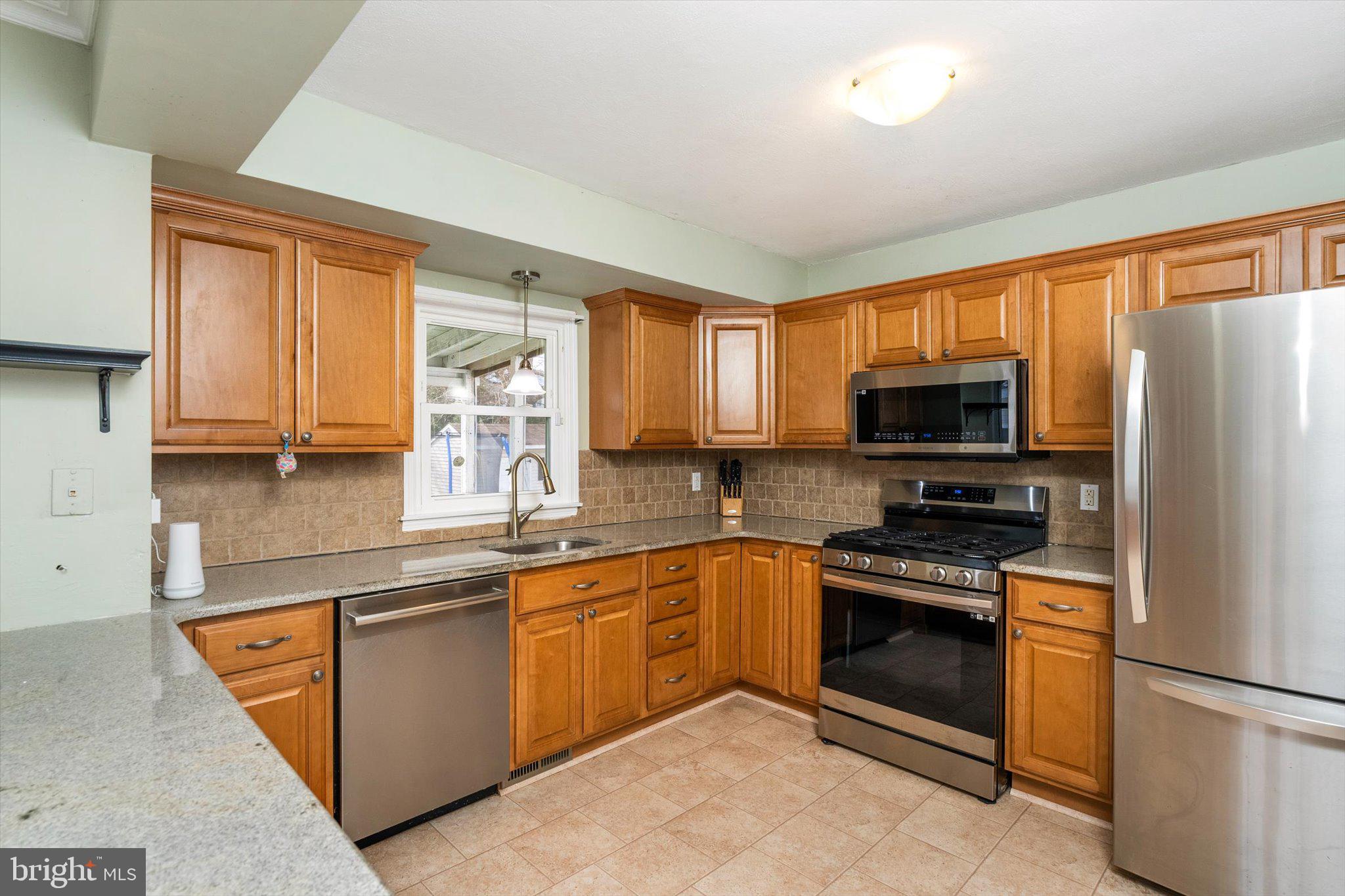 77 Gary Drive Hamilton, NJ 08690 - Photo 9 of 26 a kitchen with stainless steel appliances granite countertop a stove sink and microwave