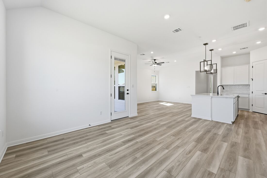 220 Wingstem Way Georgetown, TX 78633 - Photo 6 of 35 a view of a kitchen with flat screen tv and refrigerator