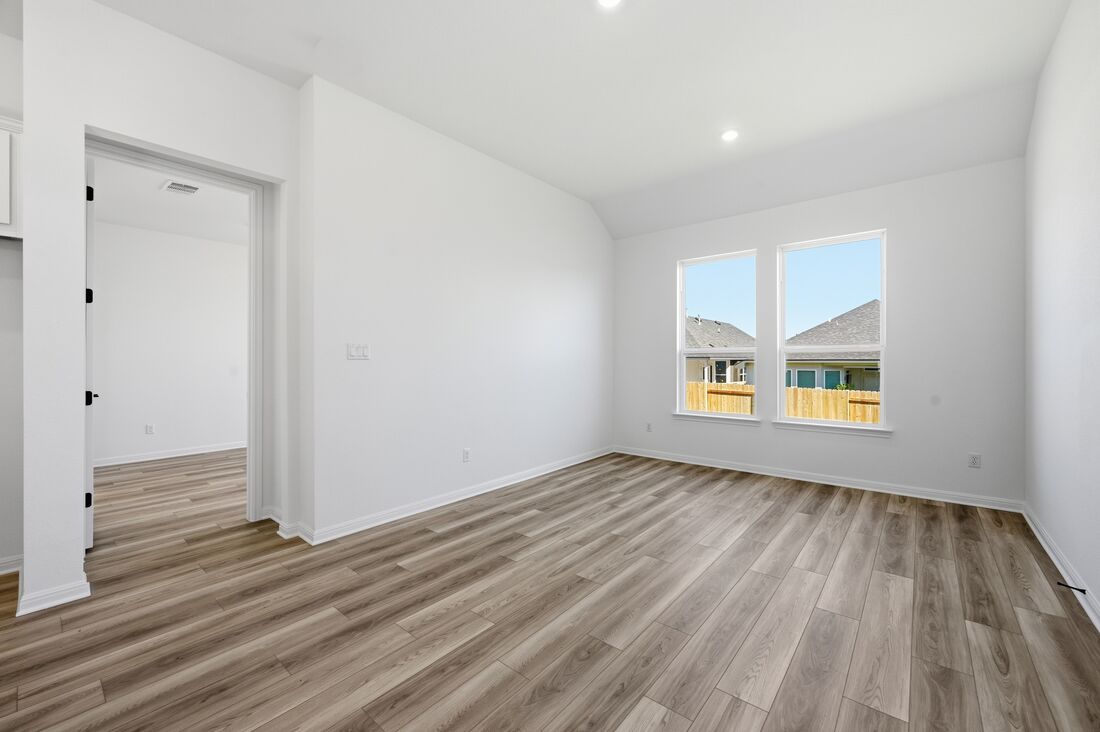 220 Wingstem Way Georgetown, TX 78633 - Photo 7 of 35 a view of an empty room with wooden floor and a window