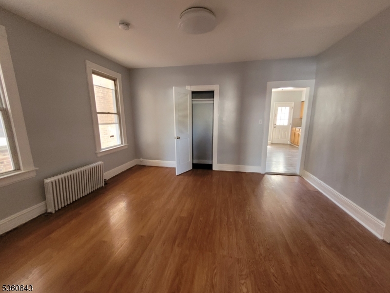 232 Niles Street Elizabeth, NJ 07202 - Photo 3 of 9 an empty room with wooden floor and windows