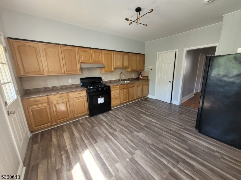 232 Niles Street Elizabeth, NJ 07202 - Photo 5 of 9 a kitchen with stainless steel appliances granite countertop a refrigerator a sink dishwasher a stove and white countertops with wooden floor