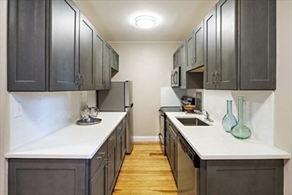 52 Strathmore Road, Unit 25 Boston, MA 02135 - Photo 5 of 12 a kitchen with a sink stove and wooden cabinets