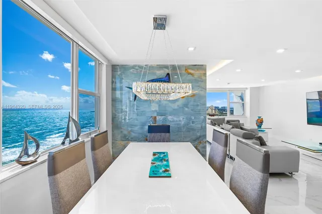 a large kitchen with stainless steel appliances a large counter top a couch and a view of living room