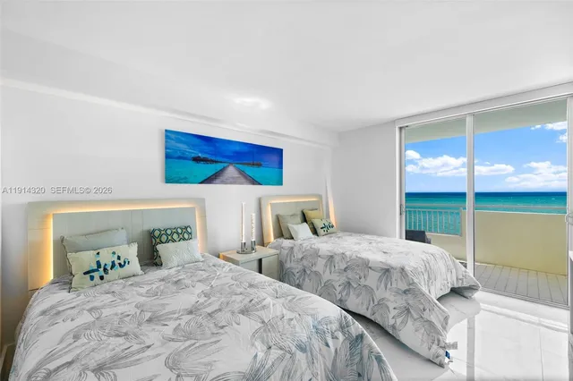 a bedroom with two beds and a large window