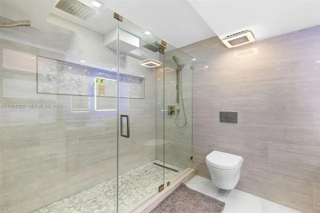 a bathroom with a toilet and a shower