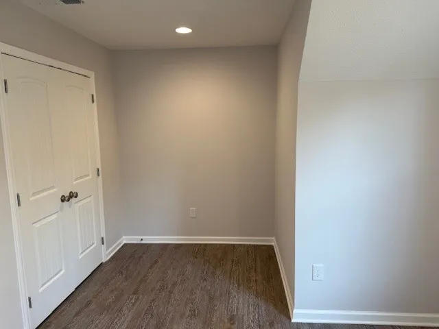 a view of a small space with wooden floor and a window