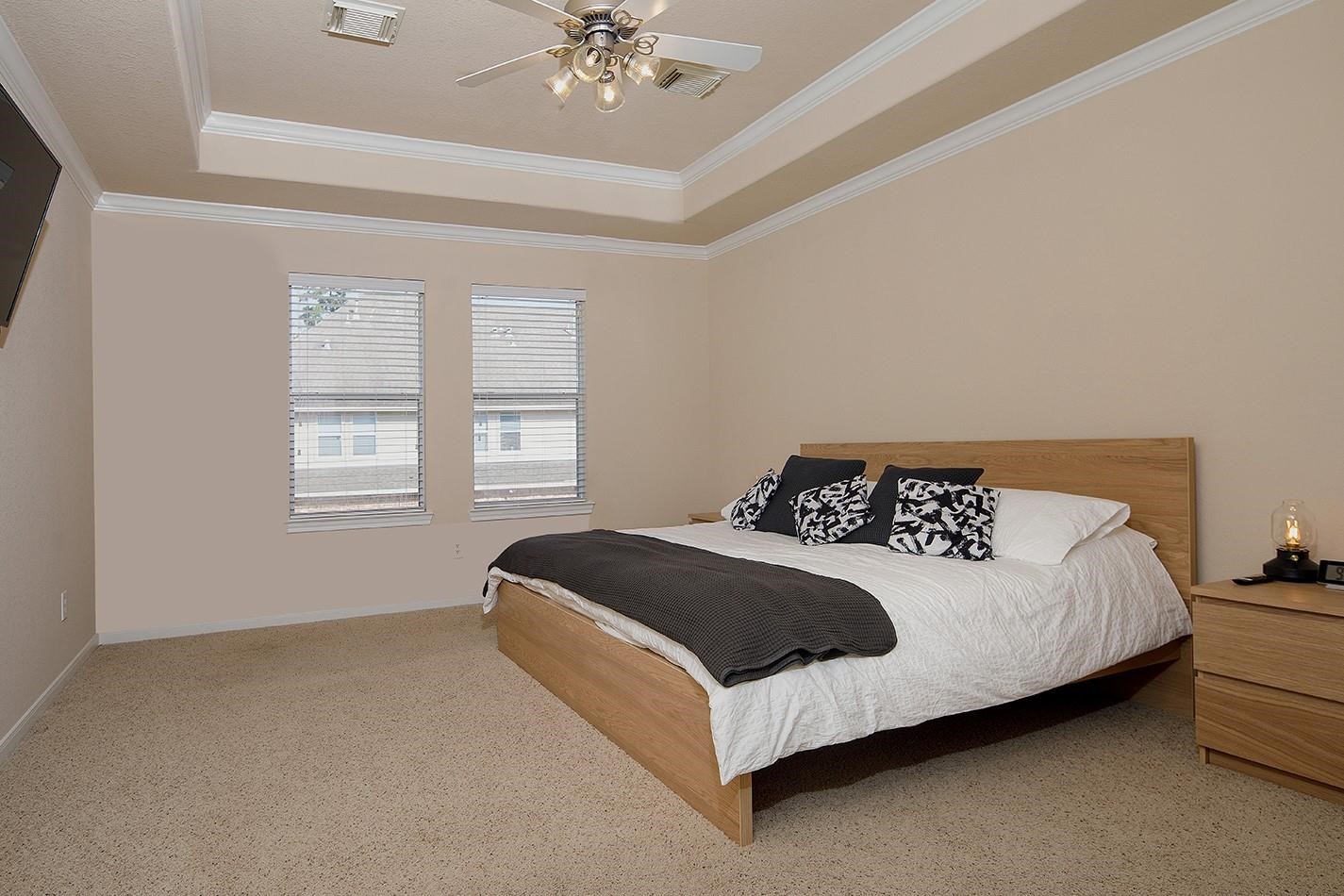 3 Pine Needle Place The Woodlands, TX 77382 - Photo 11 of 19 a spacious bedroom with a bed and a chandelier