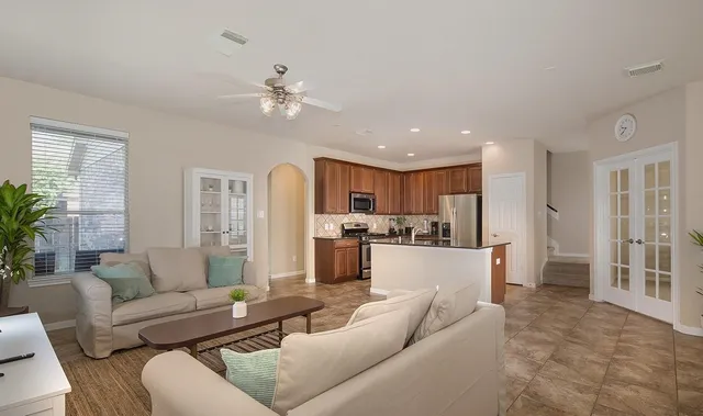 a living room with furniture white walls and kitchen view