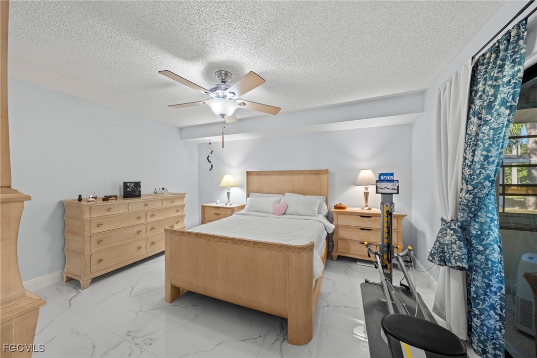 11650 Pointe Circle Fort Myers, FL 33908 - Photo 13 of 40 a bedroom with a bed and a chandelier