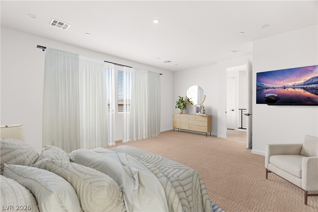 11027 Socrates Ridge Street Las Vegas, NV 89141 - Photo 4 of 20 Well-lit and tranquil primary bedroom, featuring plush carpeting and large windows with privacy blinds.