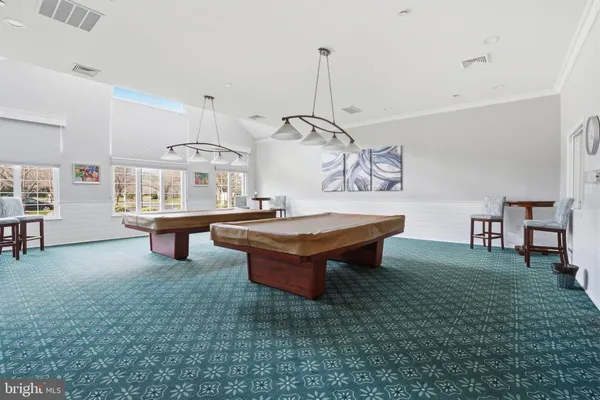 a room with pool table and windows