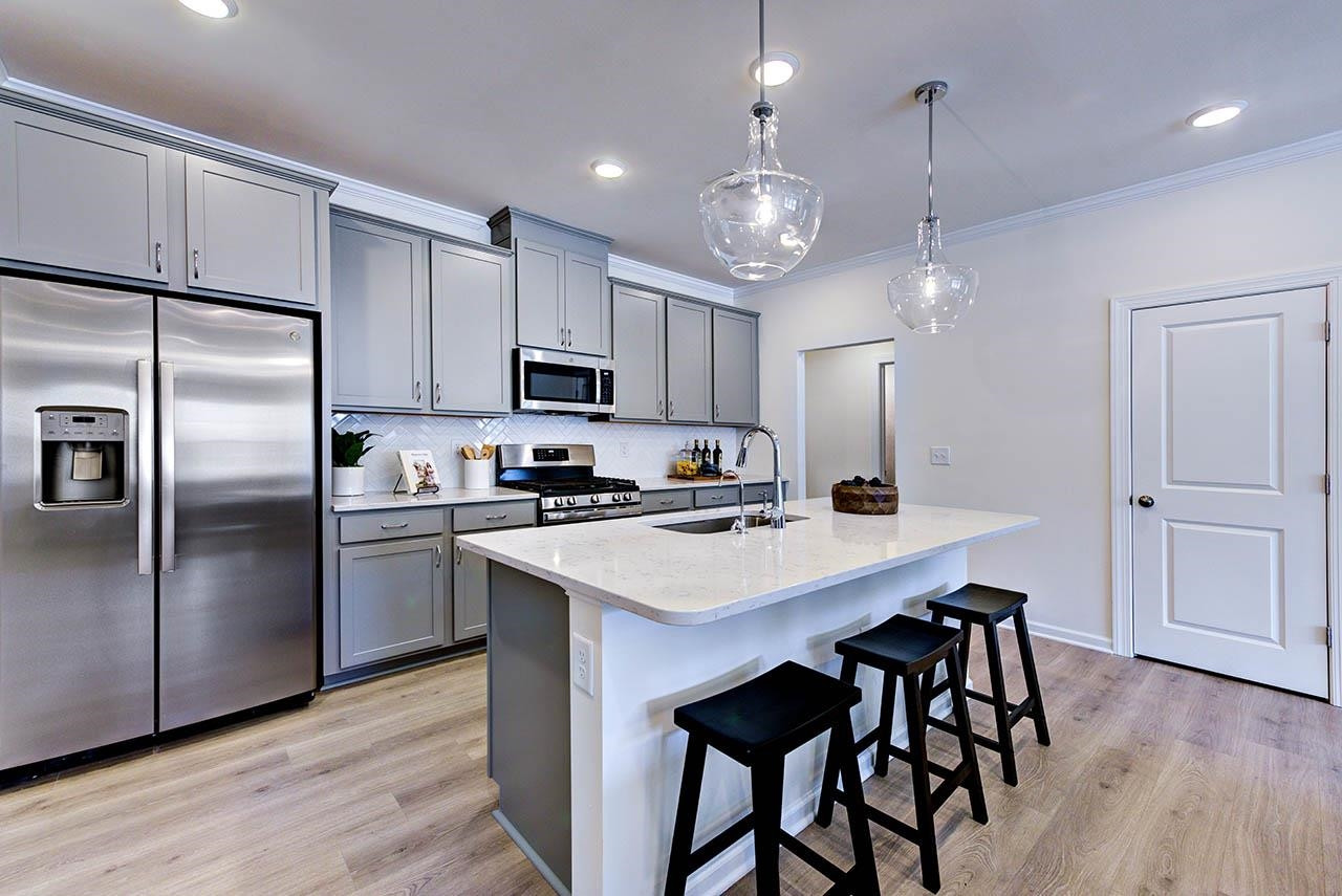 931 Baldwin Rdg Road Apex, NC 27523 - Photo 17 of 42 a kitchen with kitchen island a refrigerator a stove a sink and a refrigerator