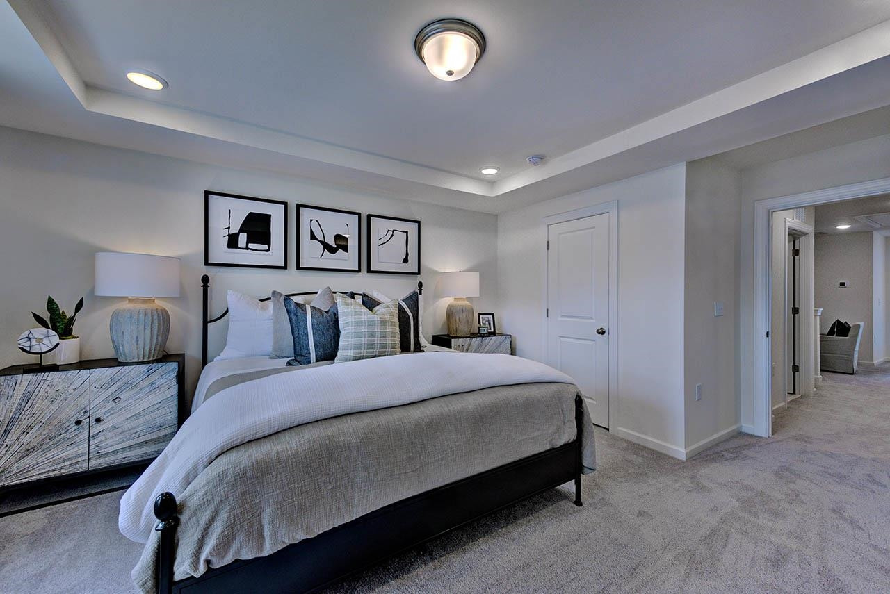 931 Baldwin Rdg Road Apex, NC 27523 - Photo 22 of 42 a spacious bedroom with a bed and painting on the wall