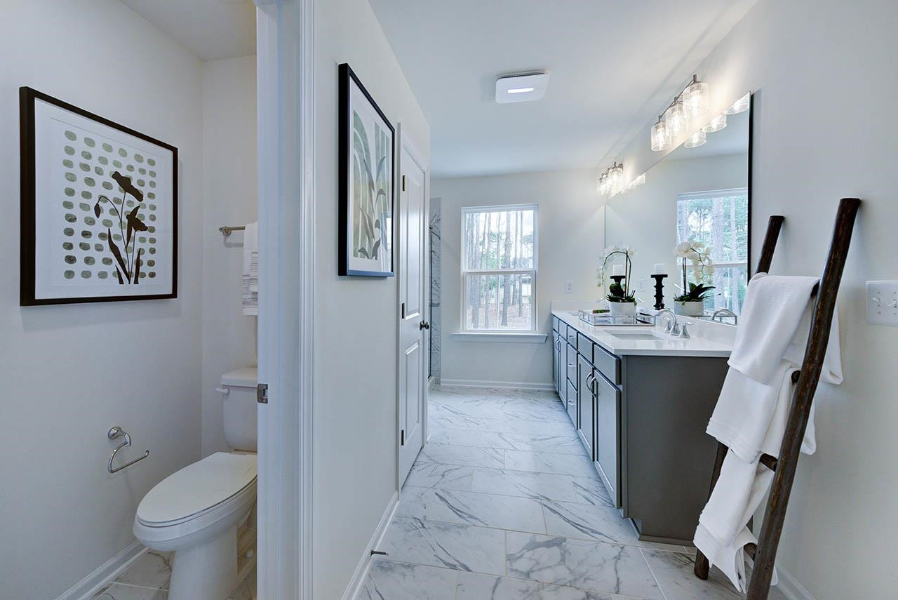 931 Baldwin Rdg Road Apex, NC 27523 - Photo 24 of 42 a bathroom with a sink a toilet and a mirror