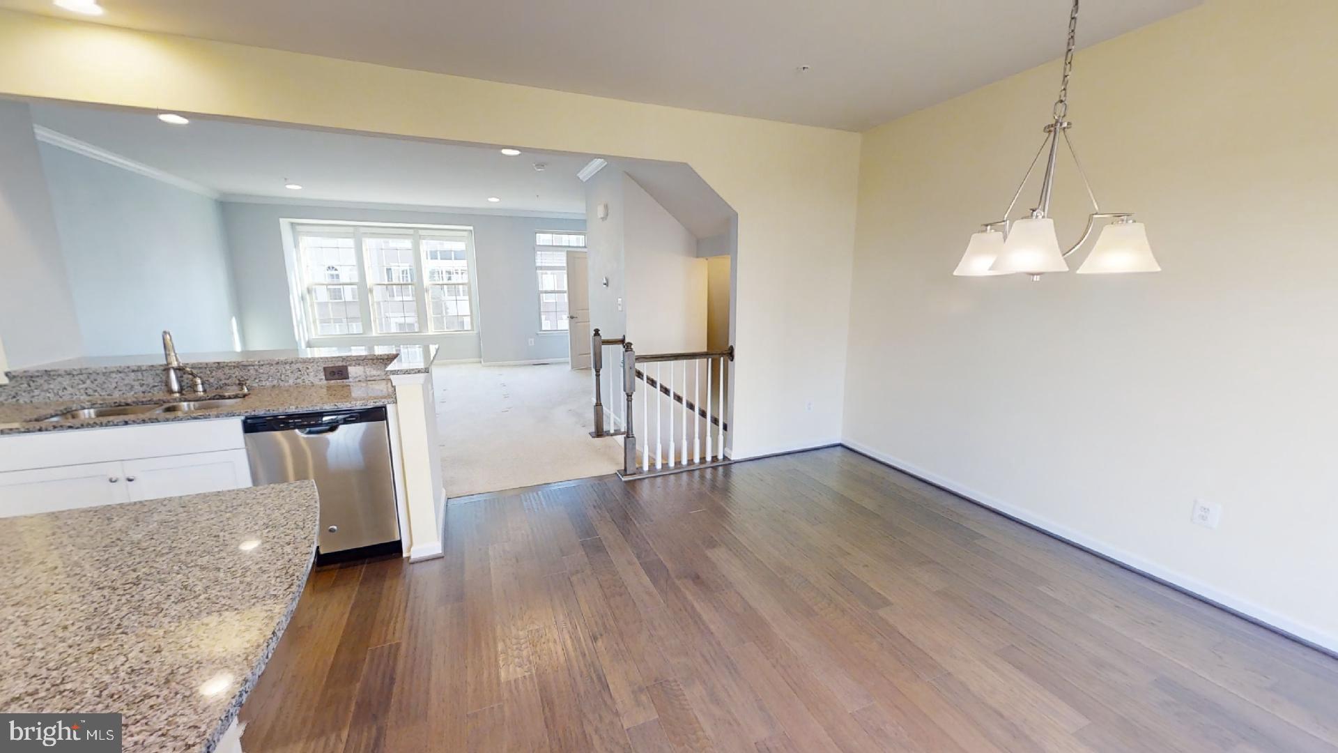 5974 Jefferson Commons Way Frederick, MD 21703 - Photo 5 of 16 a view of a kitchen with granite countertop a stove top oven a sink a dishwasher with wooden floor and cabinets