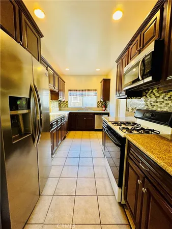 a kitchen with stainless steel appliances granite countertop a stove a sink and a microwave