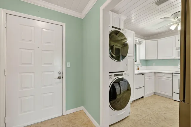 a view of an empty room with chandelier fan and a window