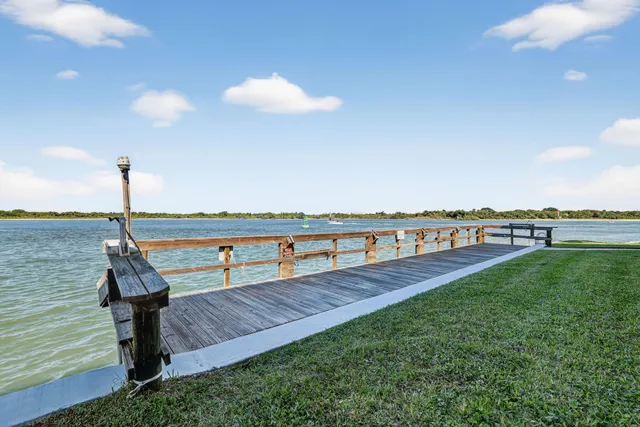 an aerial view of a house with a garden and lake view